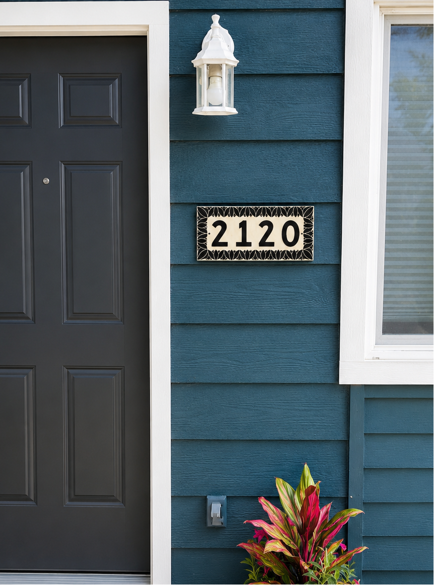 Black door and blue house exterior with house number 2120